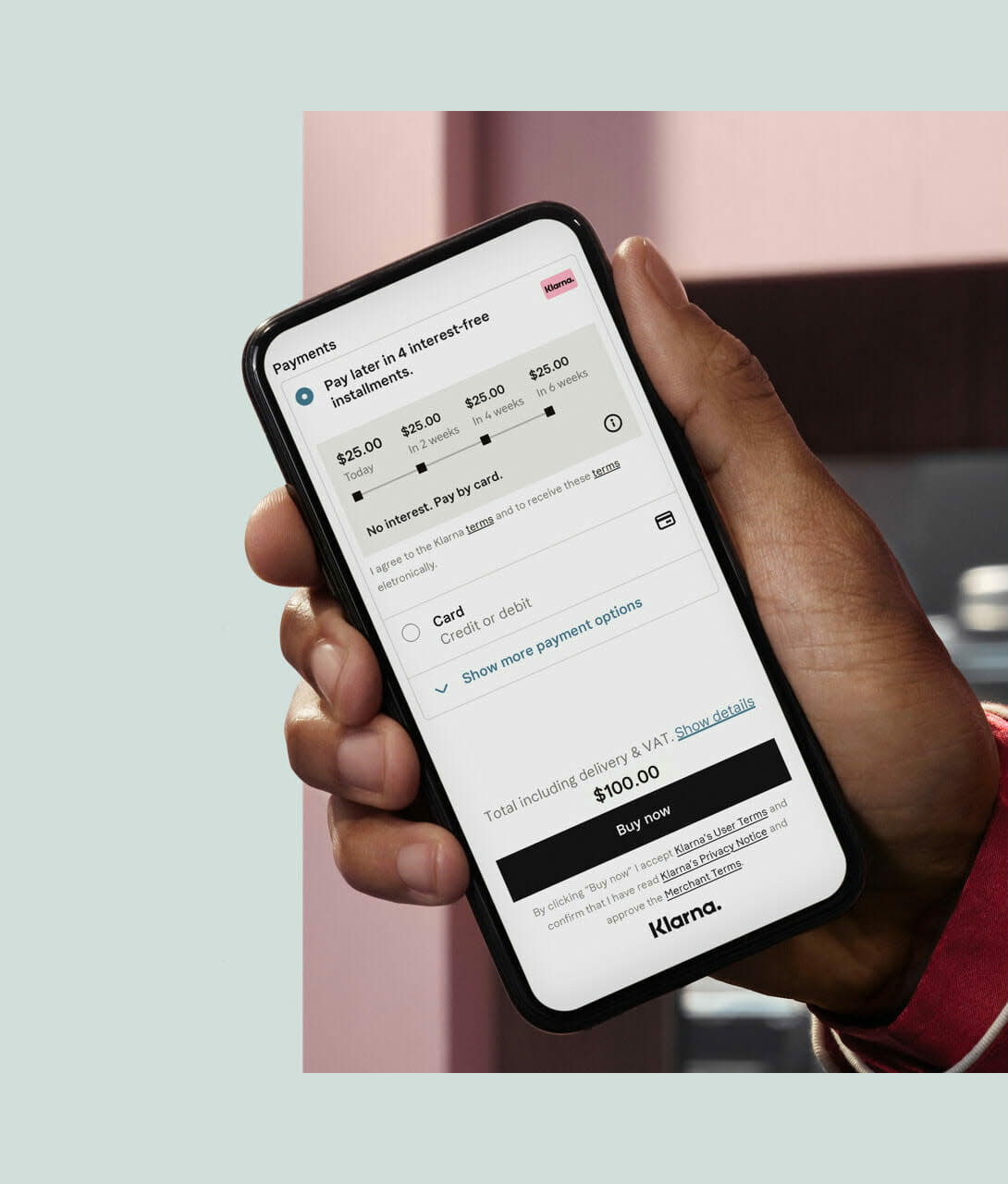 Man holding a mobile phone, on screen the Instalments payment method